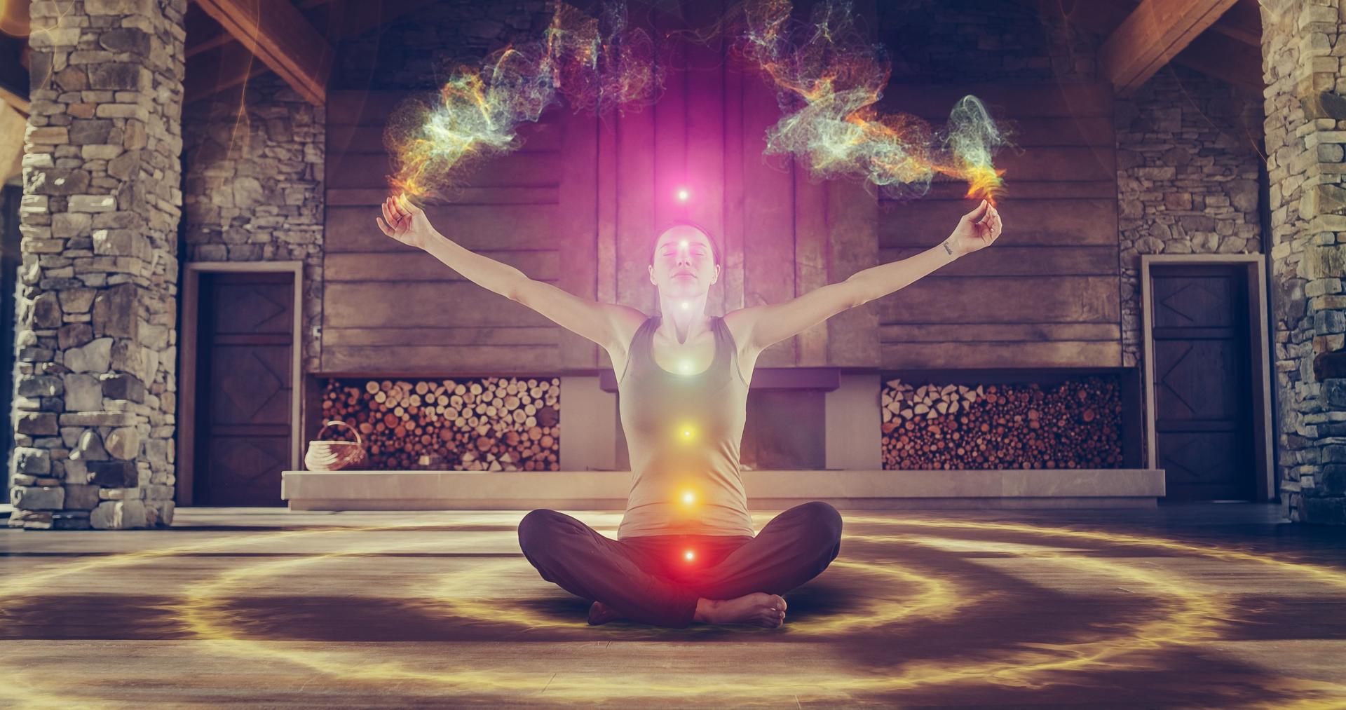 Beautiful Relaxed Caucasian Woman Meditating In Zenlike Openair Space. Edited Visualization Of Multi Colored Chakras Glowing On Her Body. Spirituality, Yoga, Self-care, Mindfulness Concept.